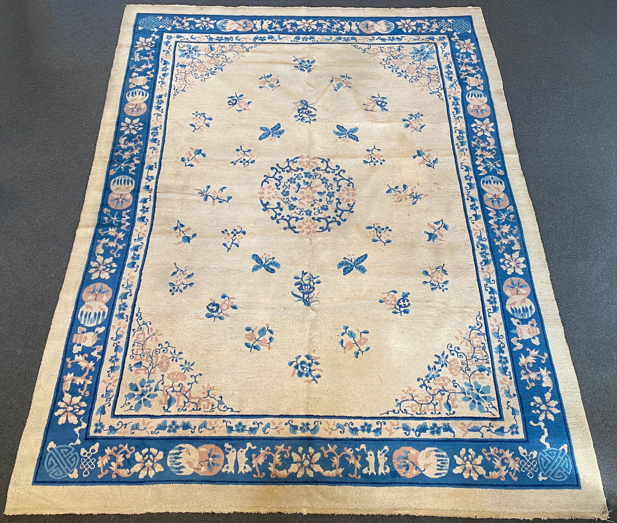 A Chinese ivory ground carpet with scattered floral field 368 x 284 cms